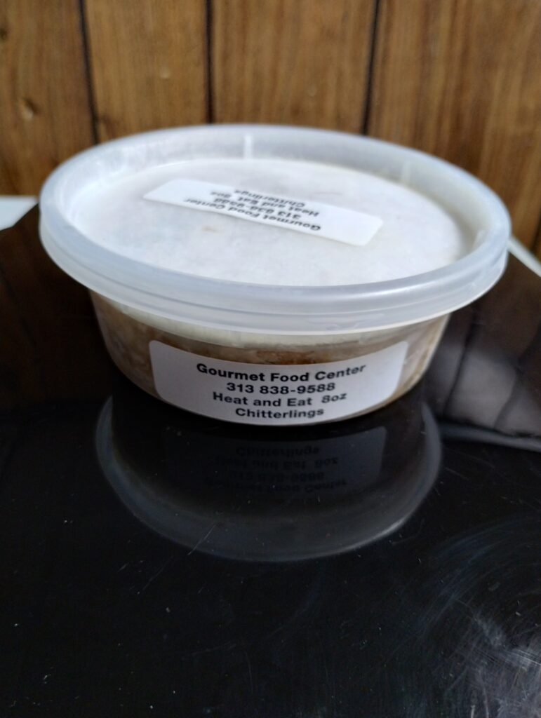 Lidded plastic tub labeled chitterlings on surface